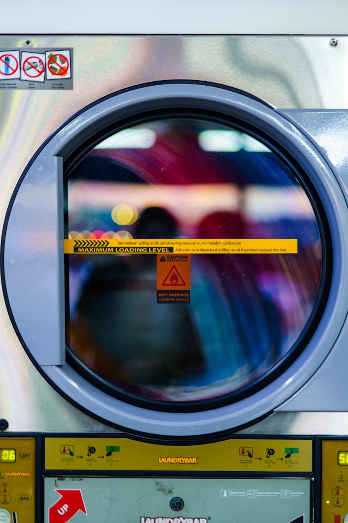 Colorful reflection in a washing machine door, showcasing laundry in motion.